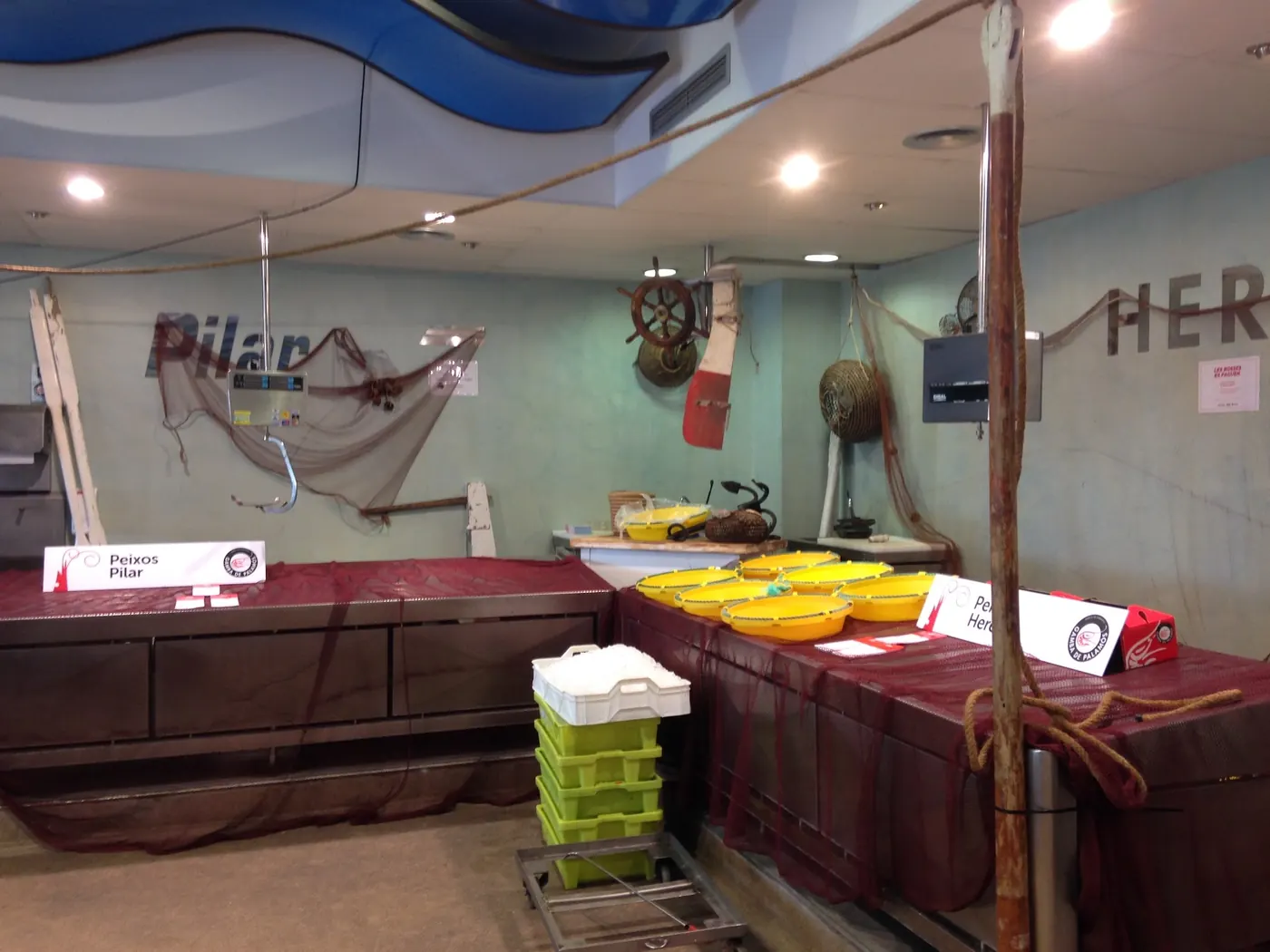La parada de Peixos Pilar al mercat, amb el rètol «Pilar» i les xarxes de pesca penjades